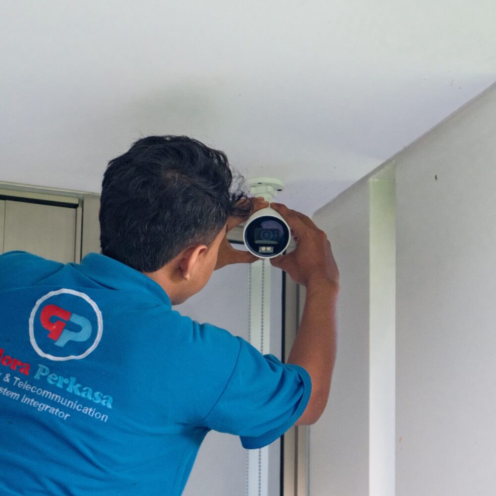 Technician adjusting a bullet CCTV camera at ceiling height